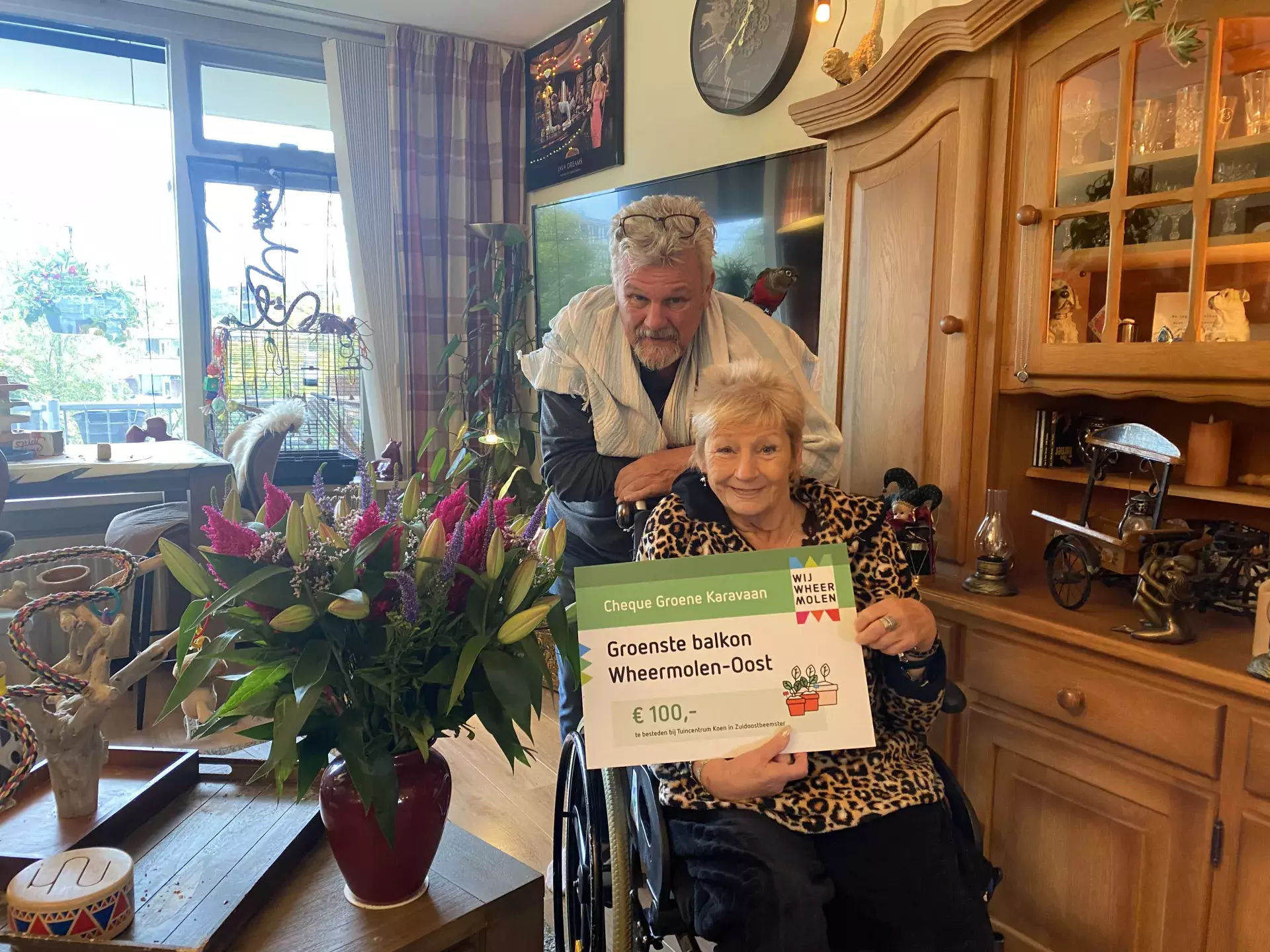 de familie geugjes met een cheque in hun woonkamer